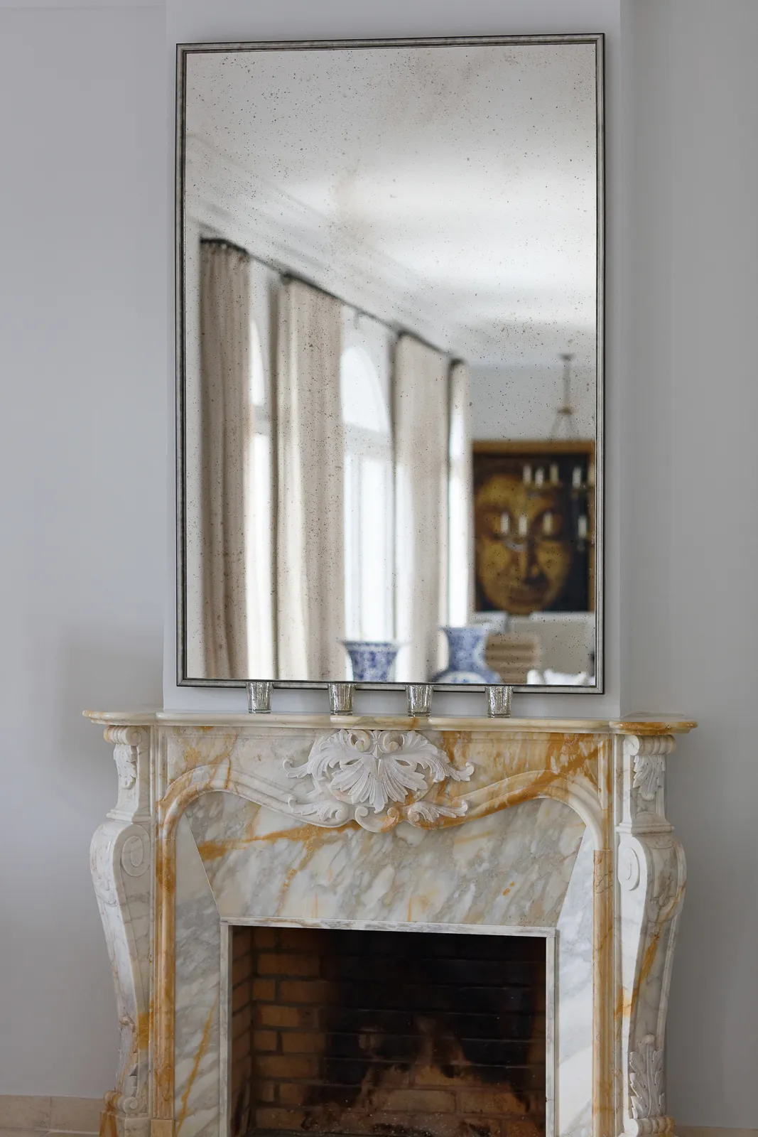 Côte d’Azur — Marble fireplace beneath a tall mirror